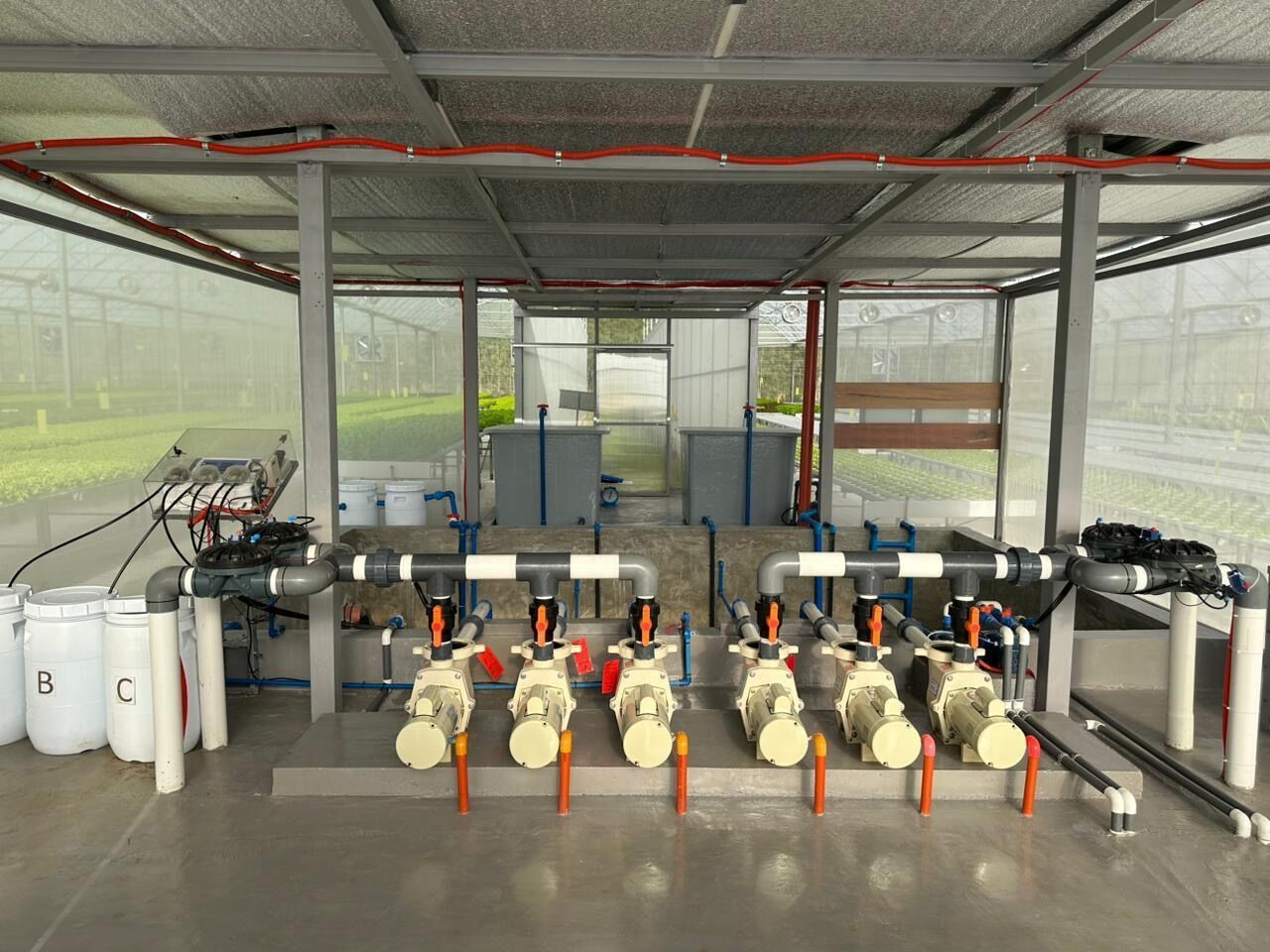 Row of nutrient dosing pumps and A, B, and C nutrient tanks in the SAREEWÂ fertigation room